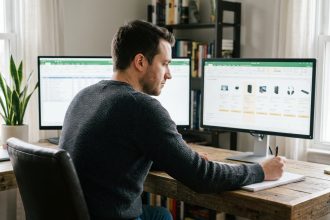 Jeune homme concentré devant deux écrans en home office